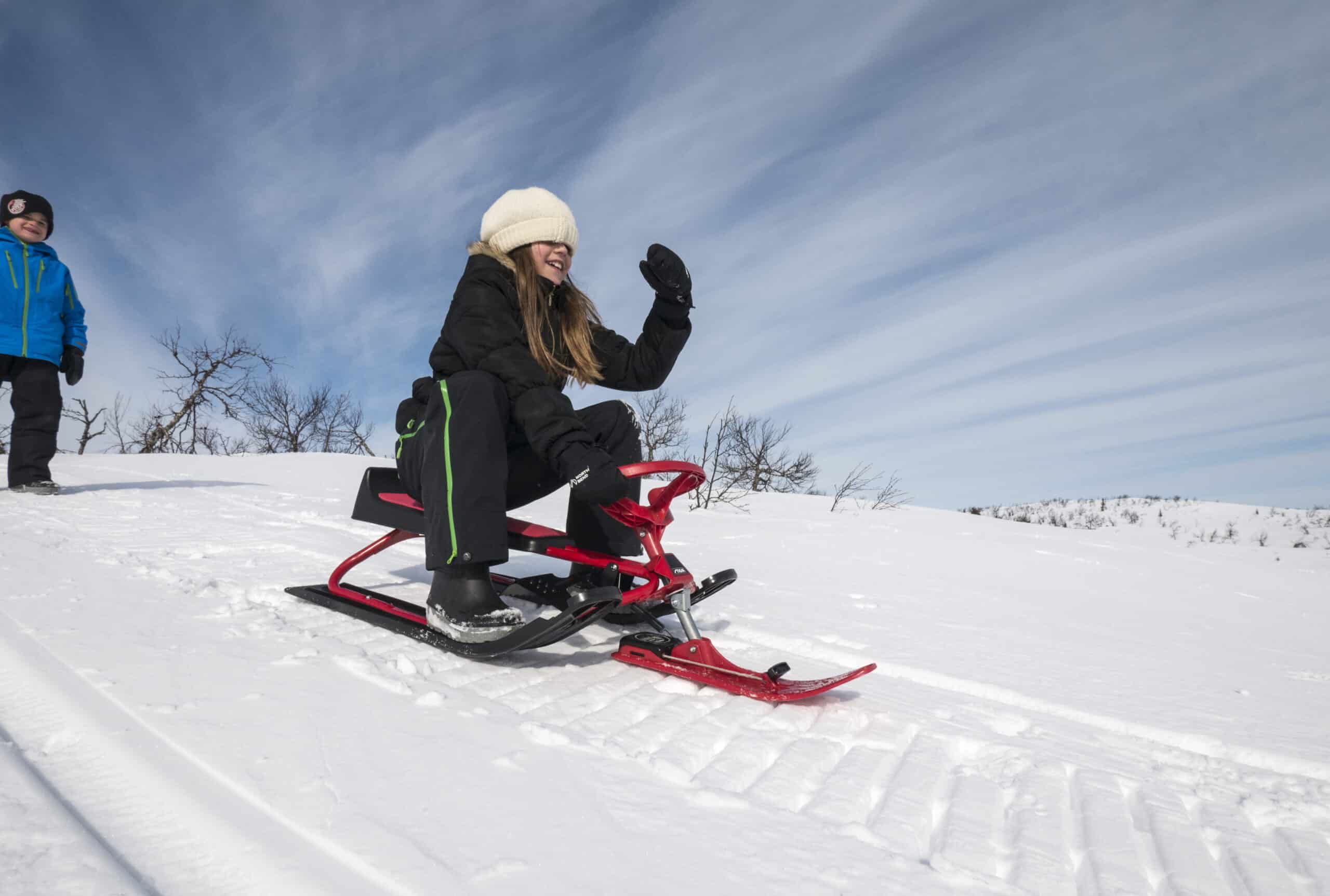 En ung tjej åker snowracer.
