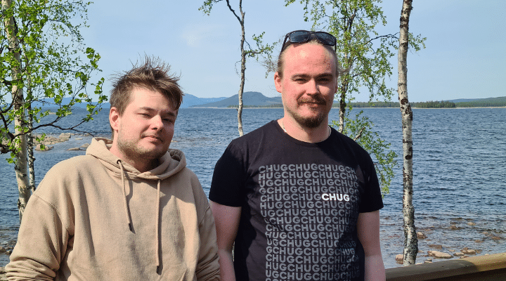 Foto av Dennis och Simon med sjön Hornavan i bakgrunden.
