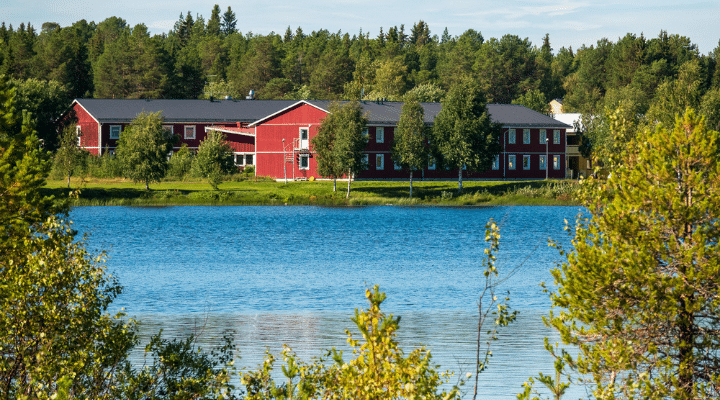 En liten sjö med ett rött hyreshus på andra sidan sjön.